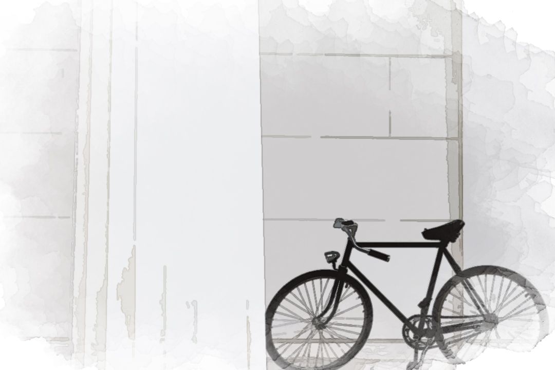 black bicycle standing on white concrete building